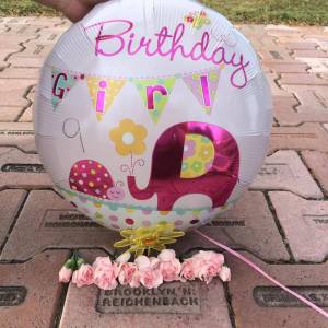 Memorial brick with birthday balloon and flowers